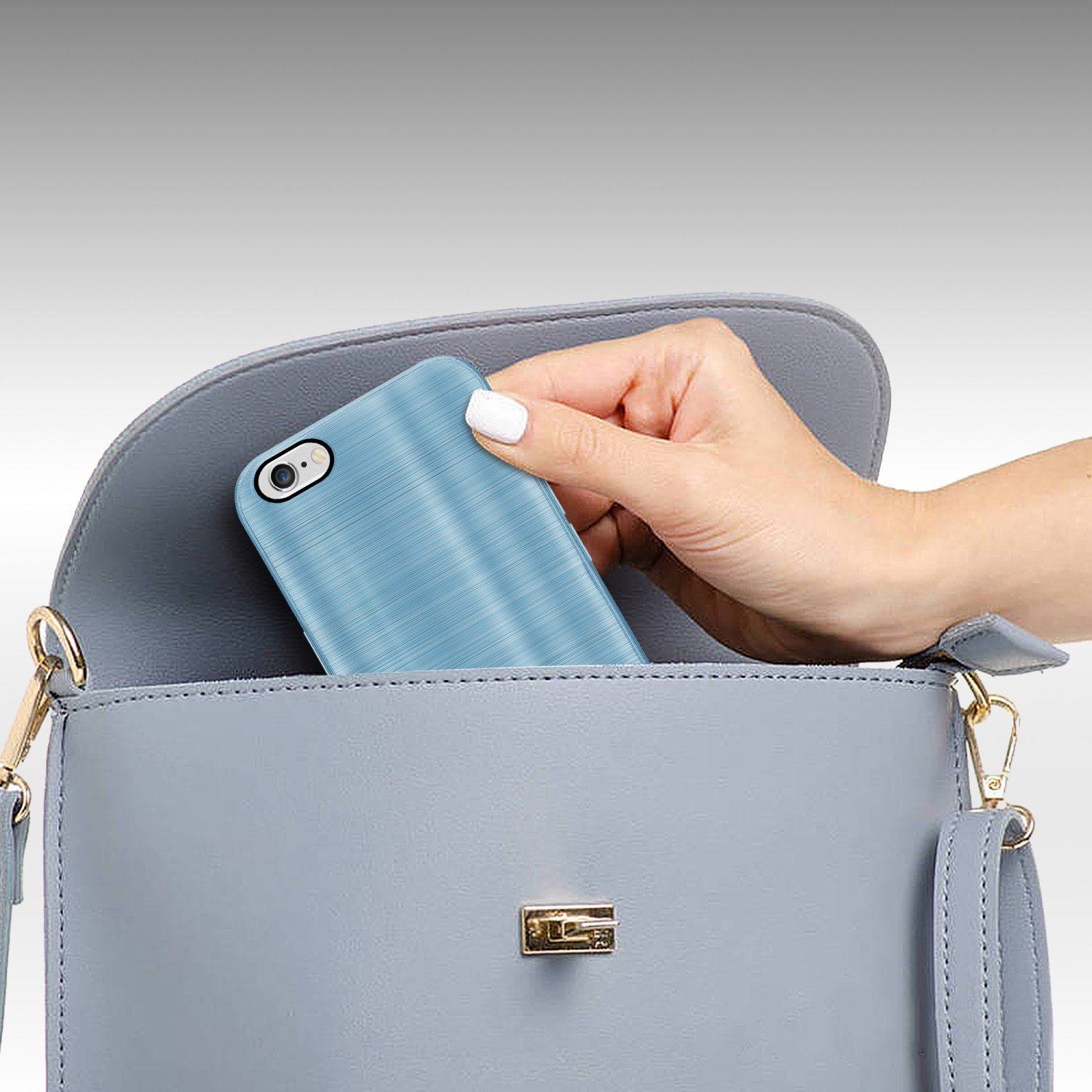 Eine Hand legt eine blaue Handyhülle mit strukturierter Oberfläche in eine graue Handtasche.