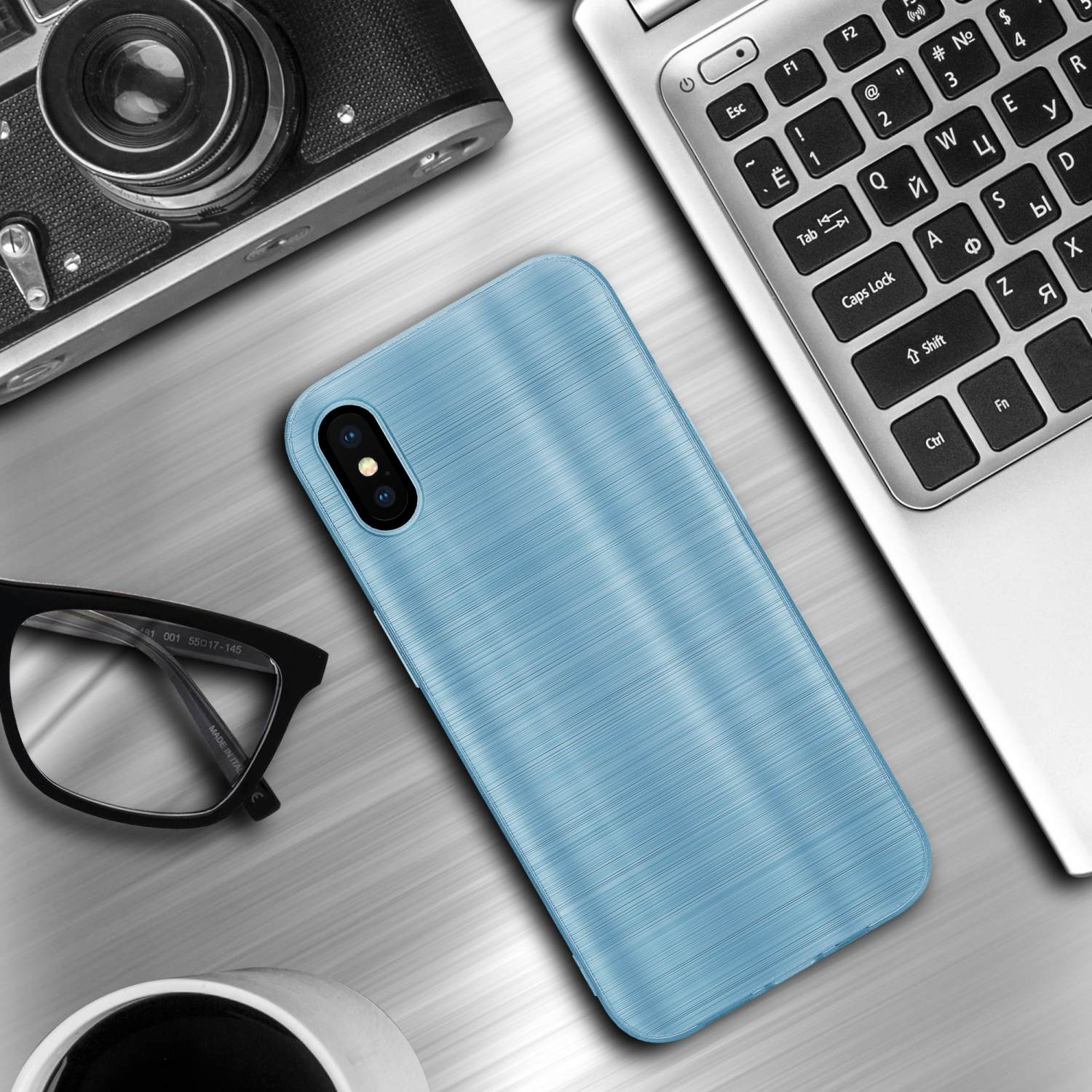 Blaue Handyhülle auf einem Schreibtisch mit Laptop, Brille und Kamera. Die Hülle hat gebürstete Optik.