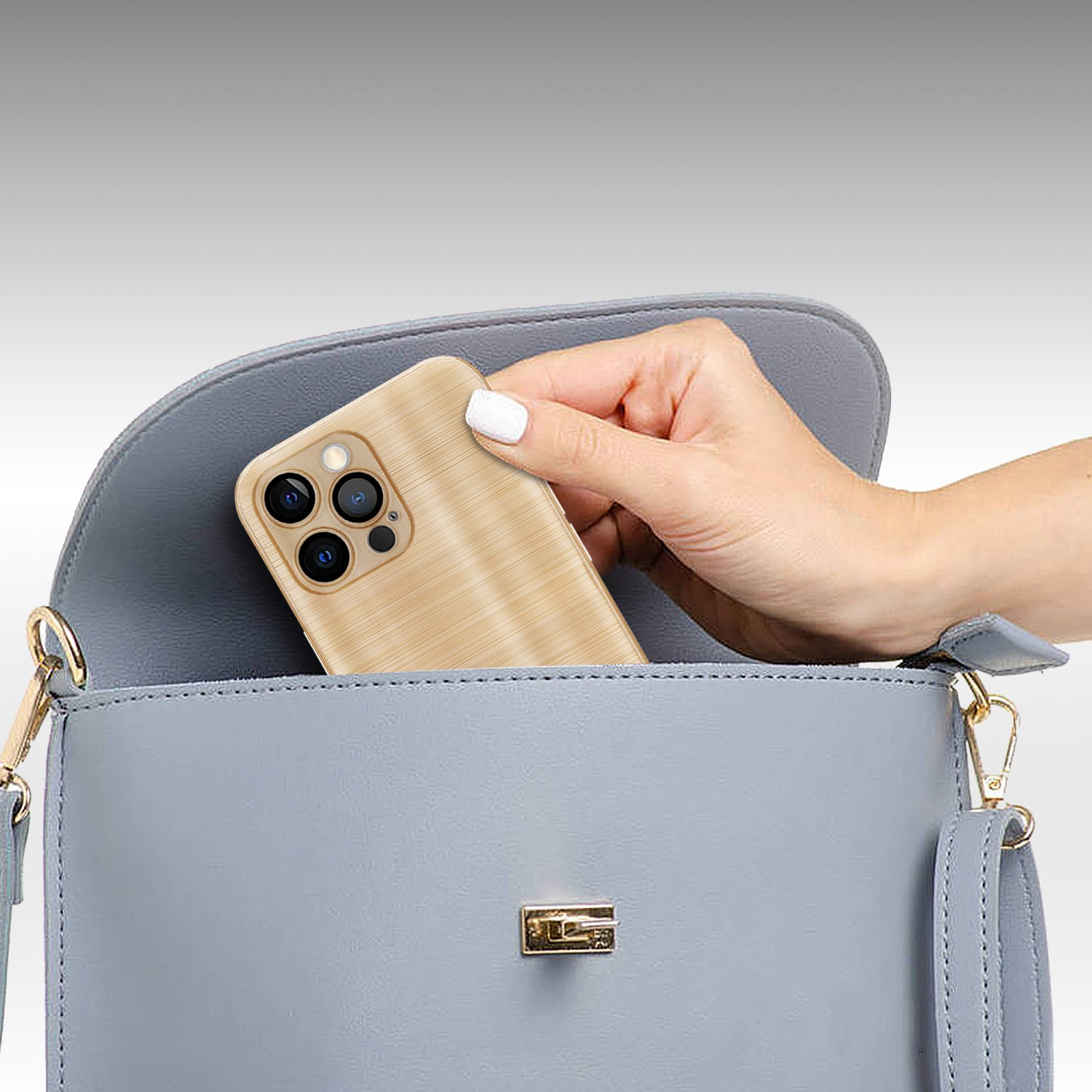 Eine Hand, die ein Telefon in eine hellblaue Handtasche legt. Das Telefon hat eine Hülle mit Holzmaserung.