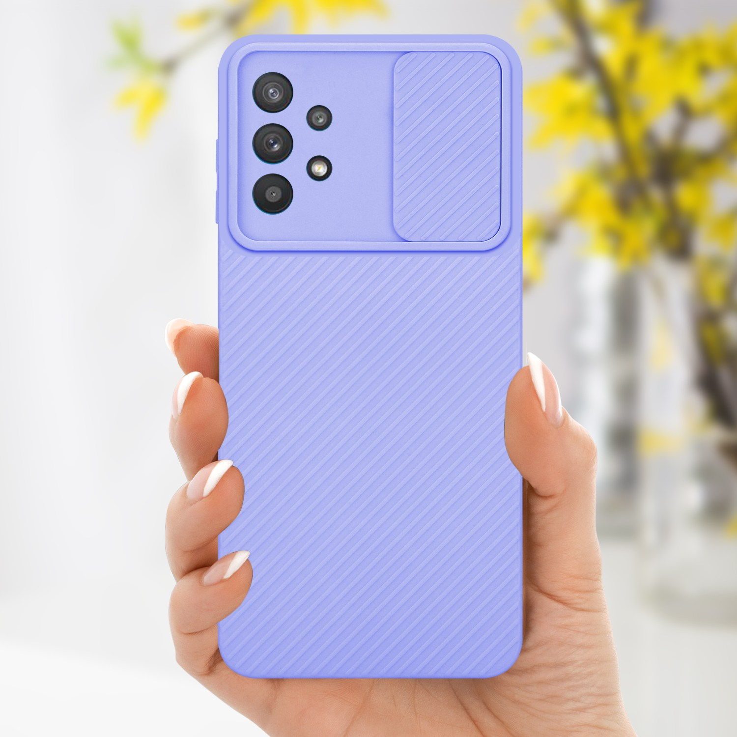Eine Hand hält eine lila Handyhülle mit Kameraabdeckung und strukturiertem Design. Hintergrund: verschwommene gelbe Blumen.
