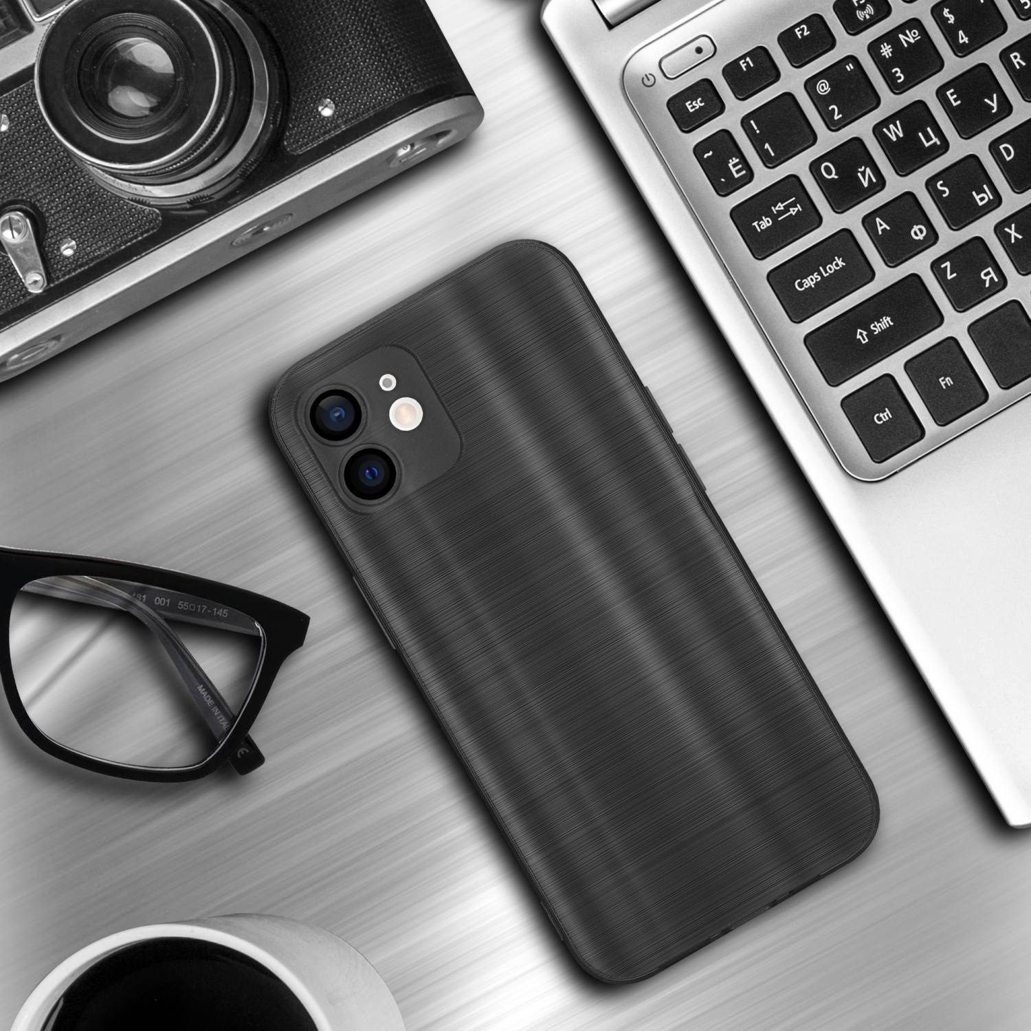 Custodia per telefono su un tavolo con un laptop e una fotocamera. La custodia è nera.