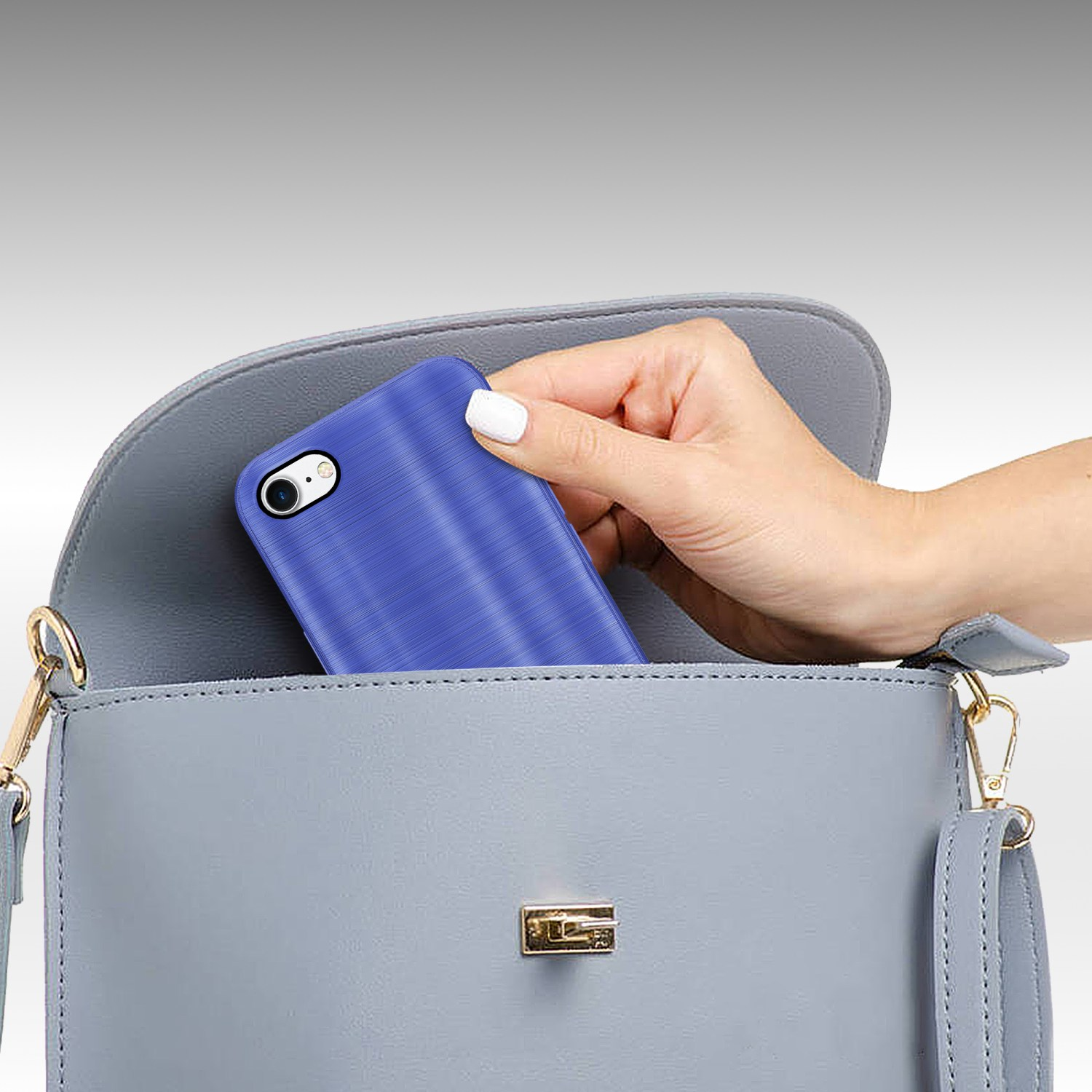 Blaue Handyhülle wird in eine graue Handtasche gelegt. Die Kamera des Telefons ist sichtbar.