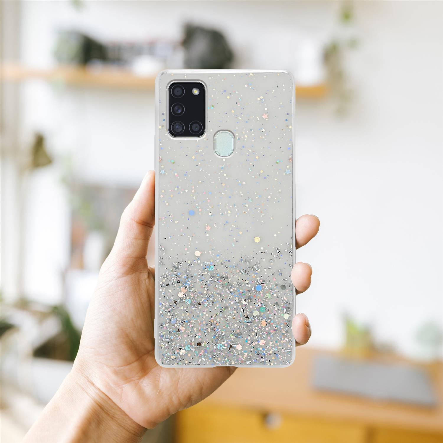 Mano che tiene una custodia per telefono con glitter. La custodia ha un design glitterato.