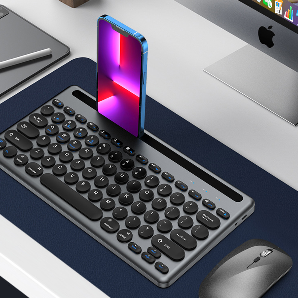 Ein blaues Telefon liegt auf einer silbernen Tastatur. Eine Maus liegt daneben auf einem blauen Pad. Der Hintergrund ist ein Schreibtisch.