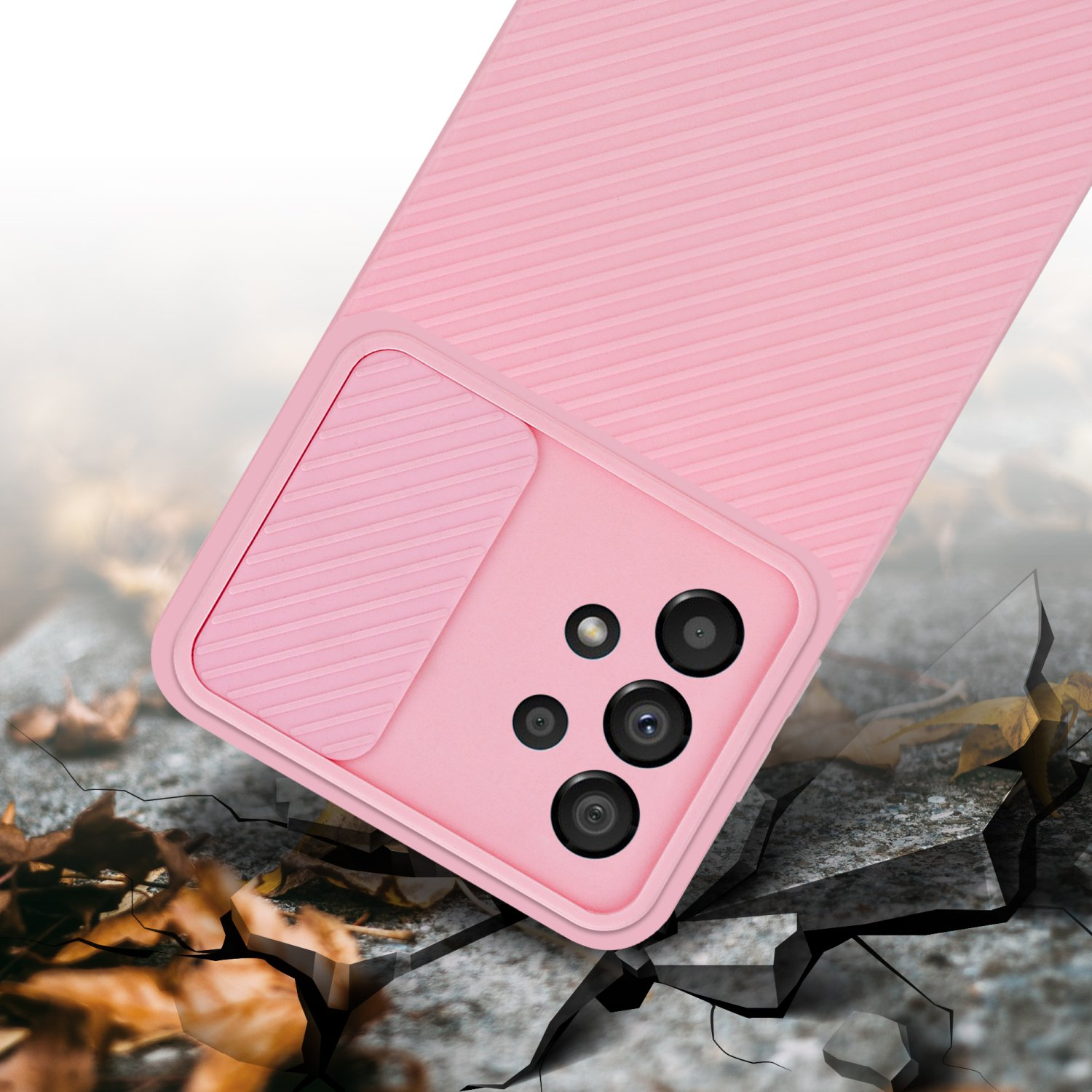Custodia rosa per telefono. Dispone di ritaglio per la fotocamera. Sfondo con superficie incrinata e foglie.