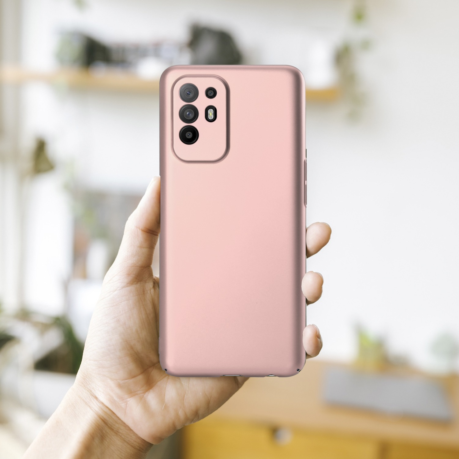 Eine Hand hält eine rosa Handyhülle mit Kameraausschnitt, Rückseite des Telefons.