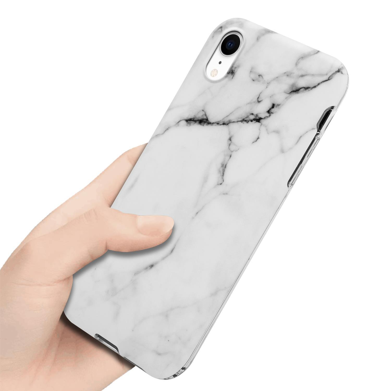 Mano che tiene un telefono con custodia in marmo. La custodia ha un design in marmo bianco. A fuoco.