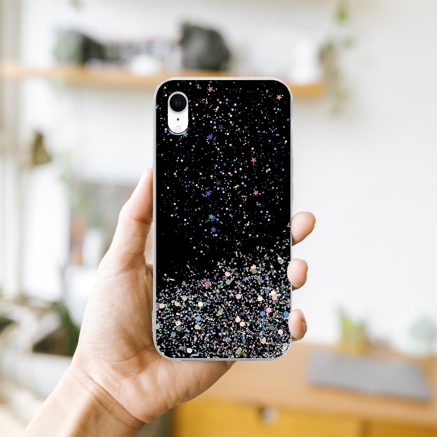 Hand, die eine schwarze Handyhülle mit Glitzerdesign hält. Schwarze Hülle mit buntem Glitzer.