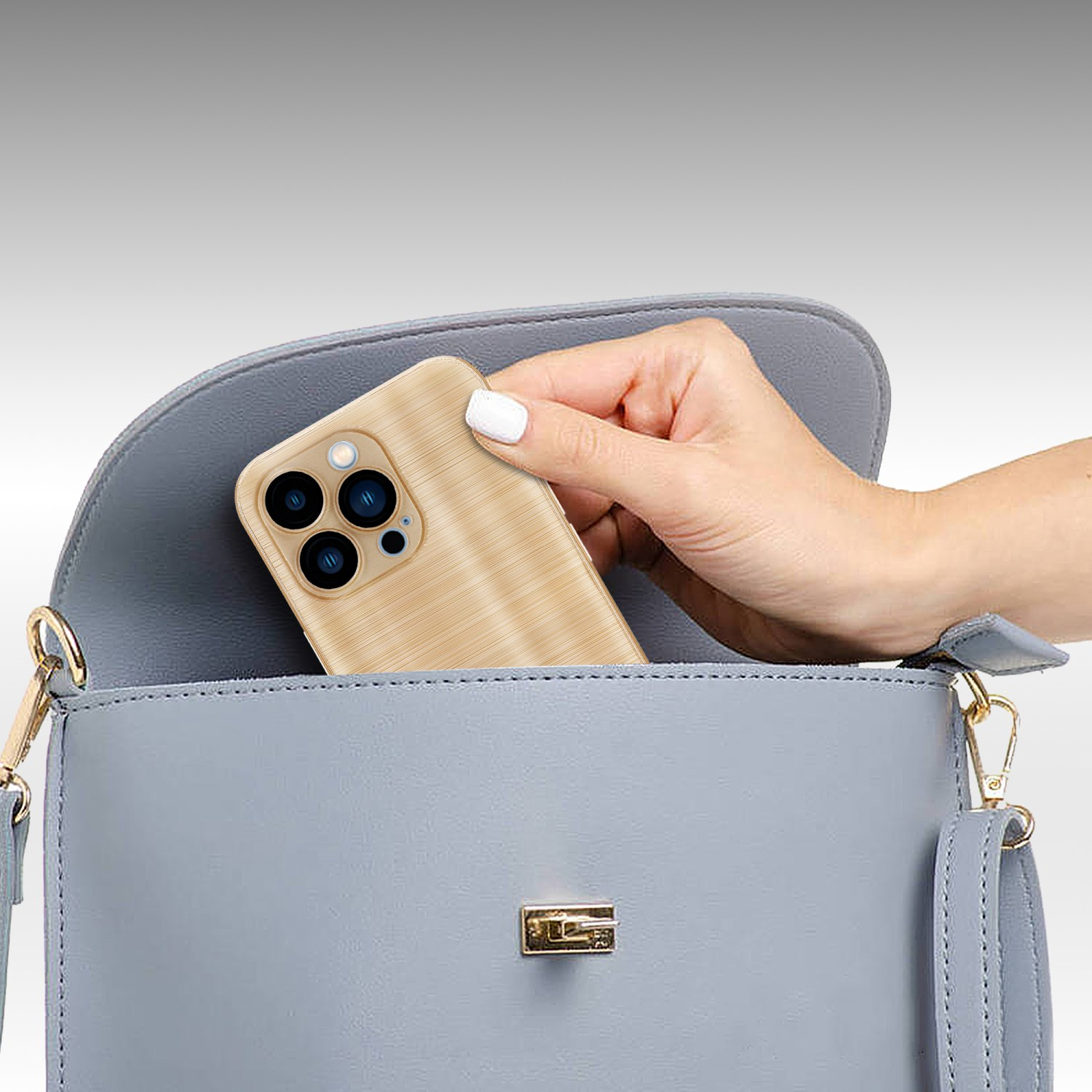 Una mano sosteniendo un teléfono con funda de vetas de madera sobre un bolso azul.