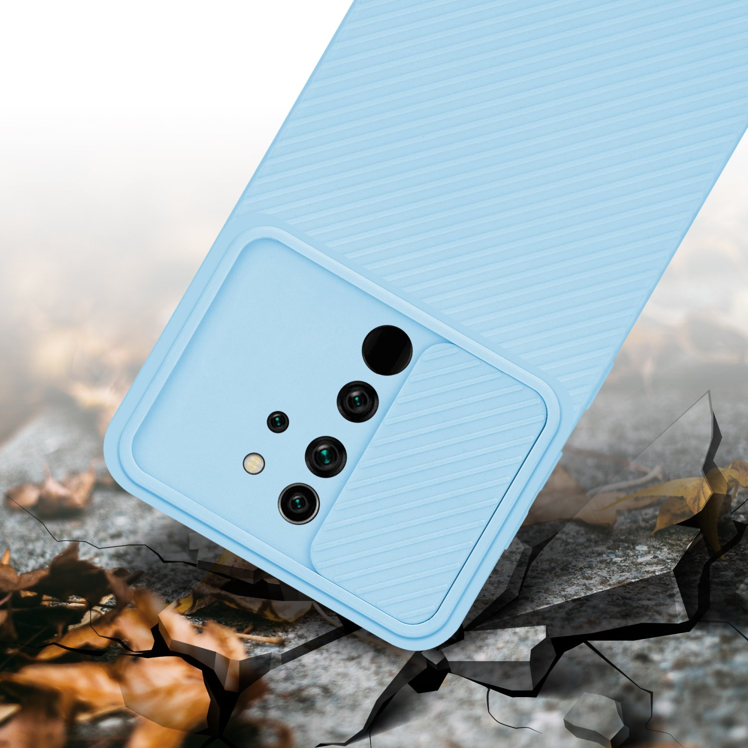 Custodia blu per telefono con ritagli per fotocamera, su superficie di cemento crepato. Foglie marroni.