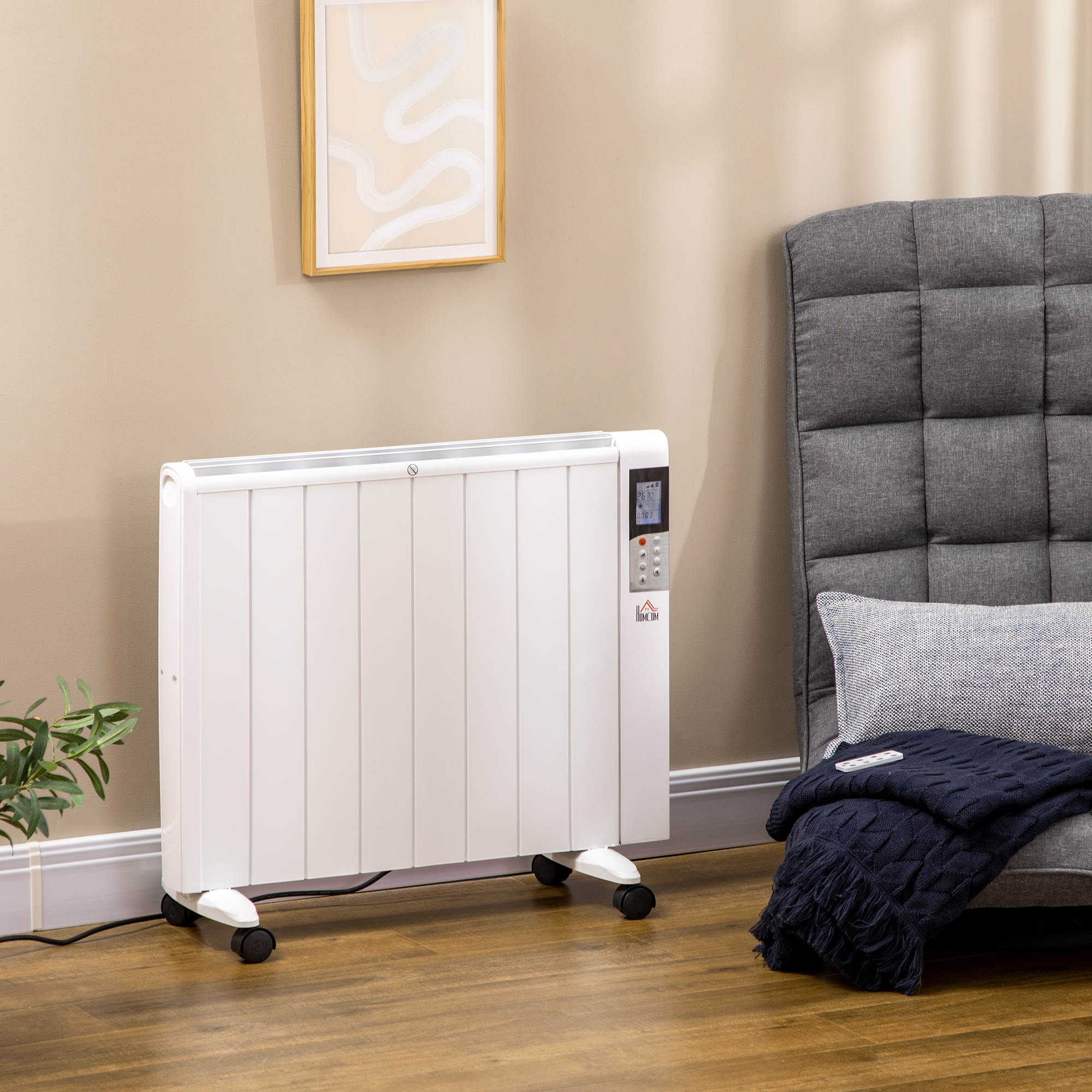 Stufa elettrica bianca su ruote, con display digitale e coperta su un divano grigio. Parete beige chiaro.