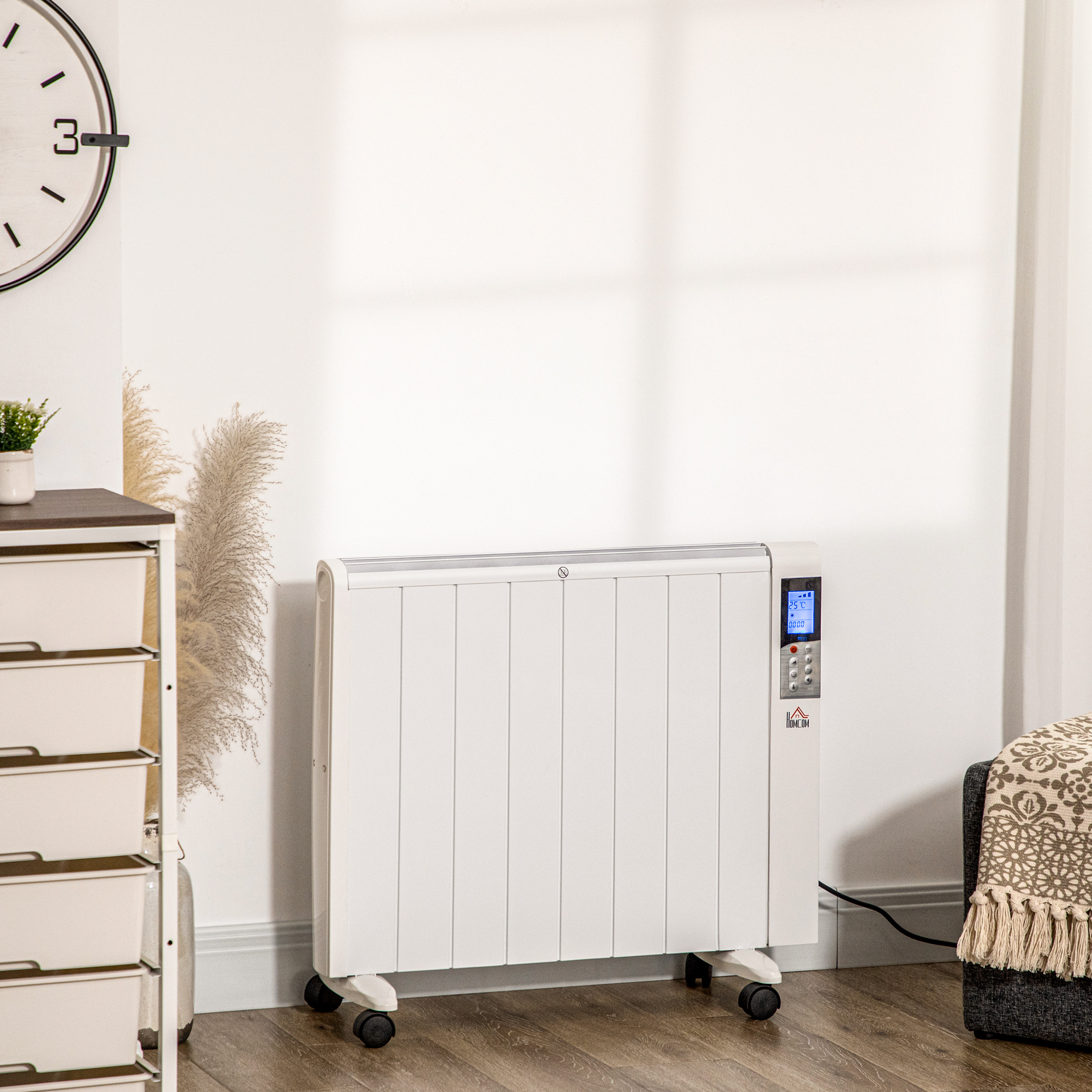Un radiatore elettrico bianco su ruote davanti a un muro bianco, con un orologio e un armadio.