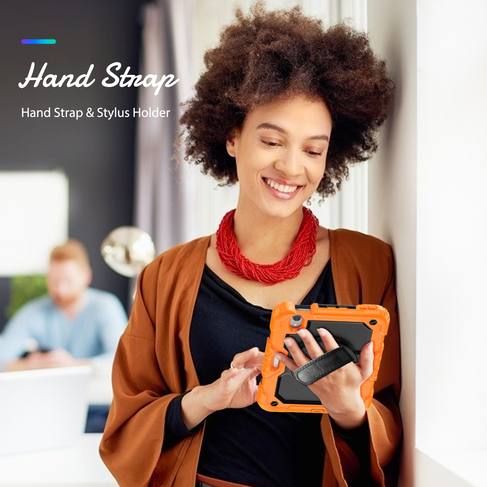 Frau hält orangefarbene Tablet-Hülle mit Handschlaufe. Hintergrund zeigt einen Mann und ein Fenster.