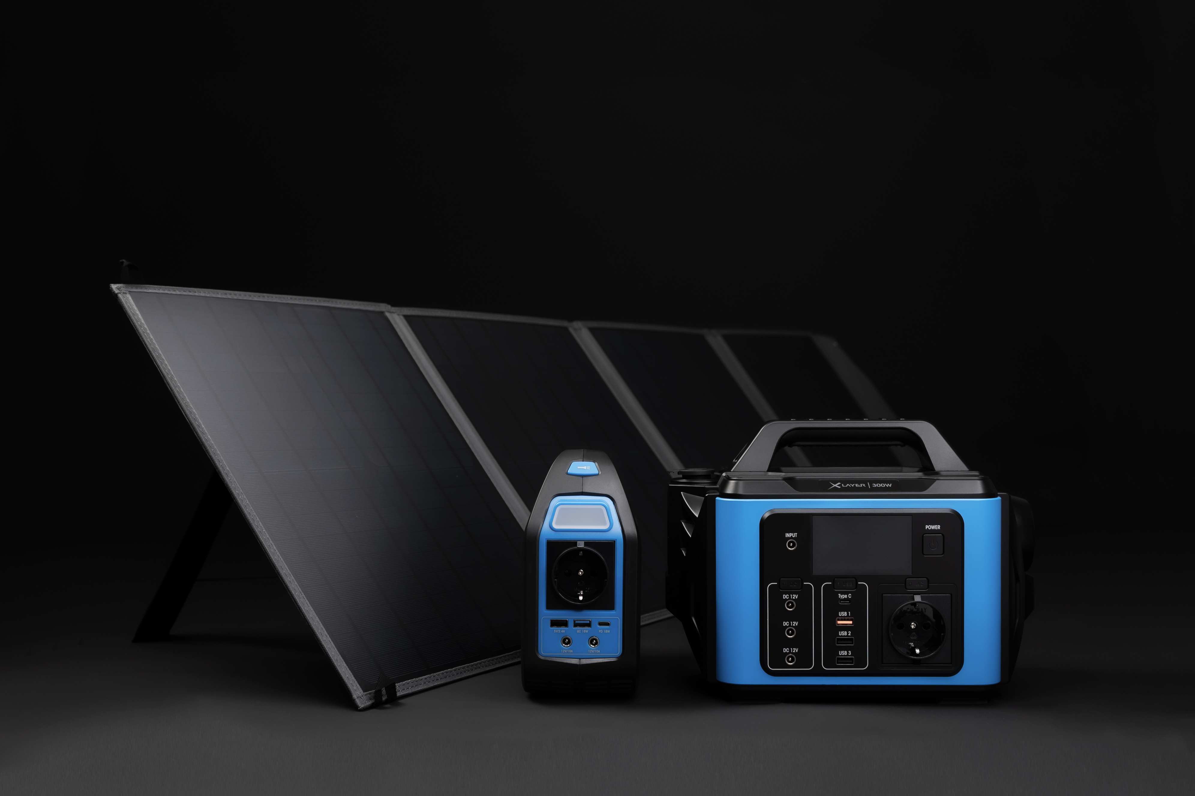 Panel słoneczny i dwie elektrownie na czarnym tle.