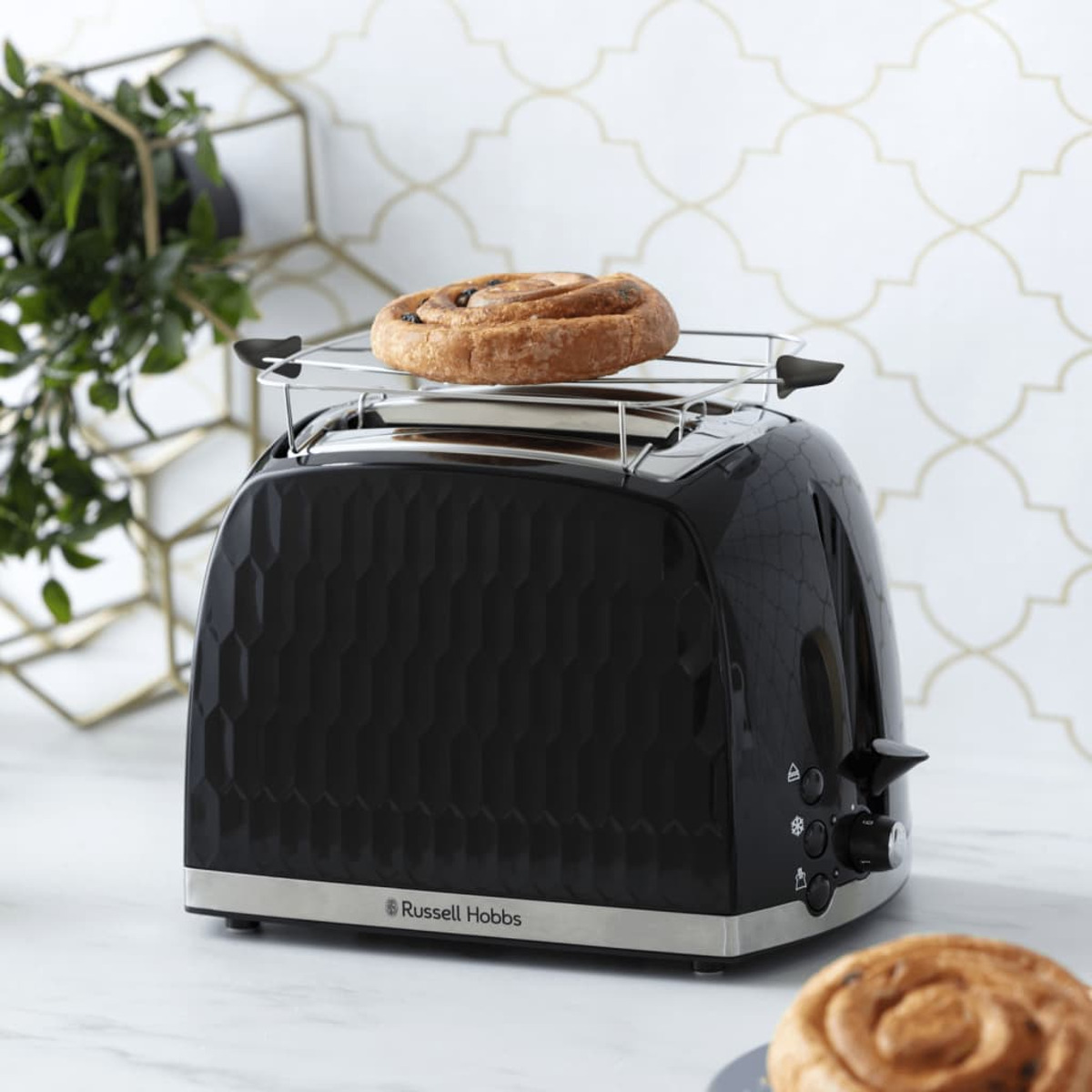 Schwarzer Toaster mit gebackenem Gebäck, auf einer Theke.