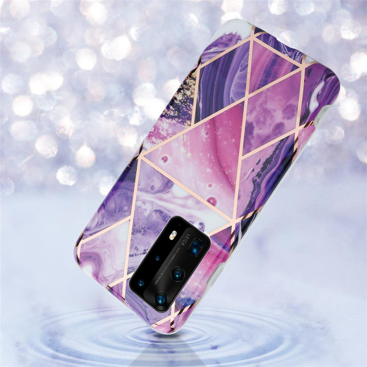Una custodia per telefono con un motivo geometrico in rosa, viola e oro, su una superficie d'acqua sfocata.