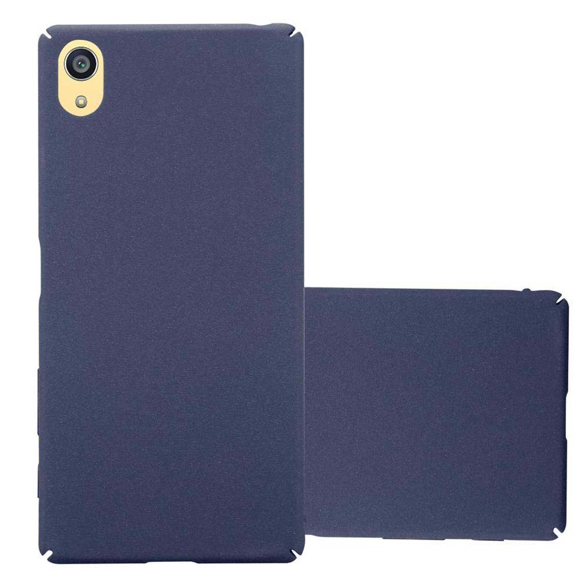 Una funda de teléfono azul oscuro junto a un teléfono, ambos con superficies lisas.