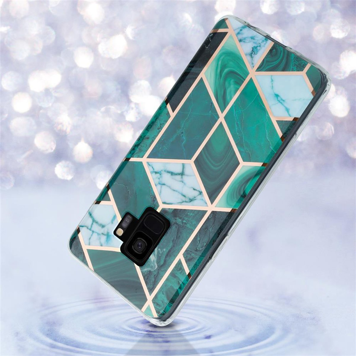 Una custodia per telefono verde e oro su sfondo azzurro. La custodia ha un motivo geometrico.