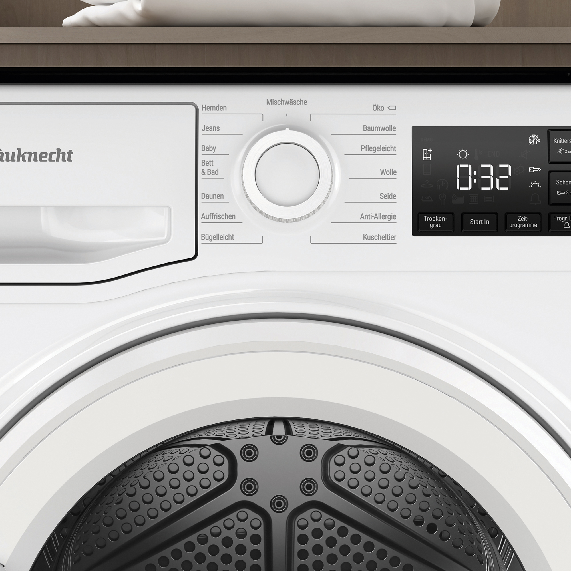 Nahaufnahme des Bedienfelds einer weißen Waschmaschine. Verschiedene Einstellungen, ein Drehknopf und eine Digitalanzeige.