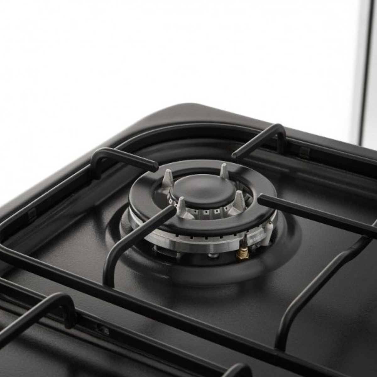 Primer plano de un quemador de estufa de gas negro con un difusor de llama circular y soportes negros.