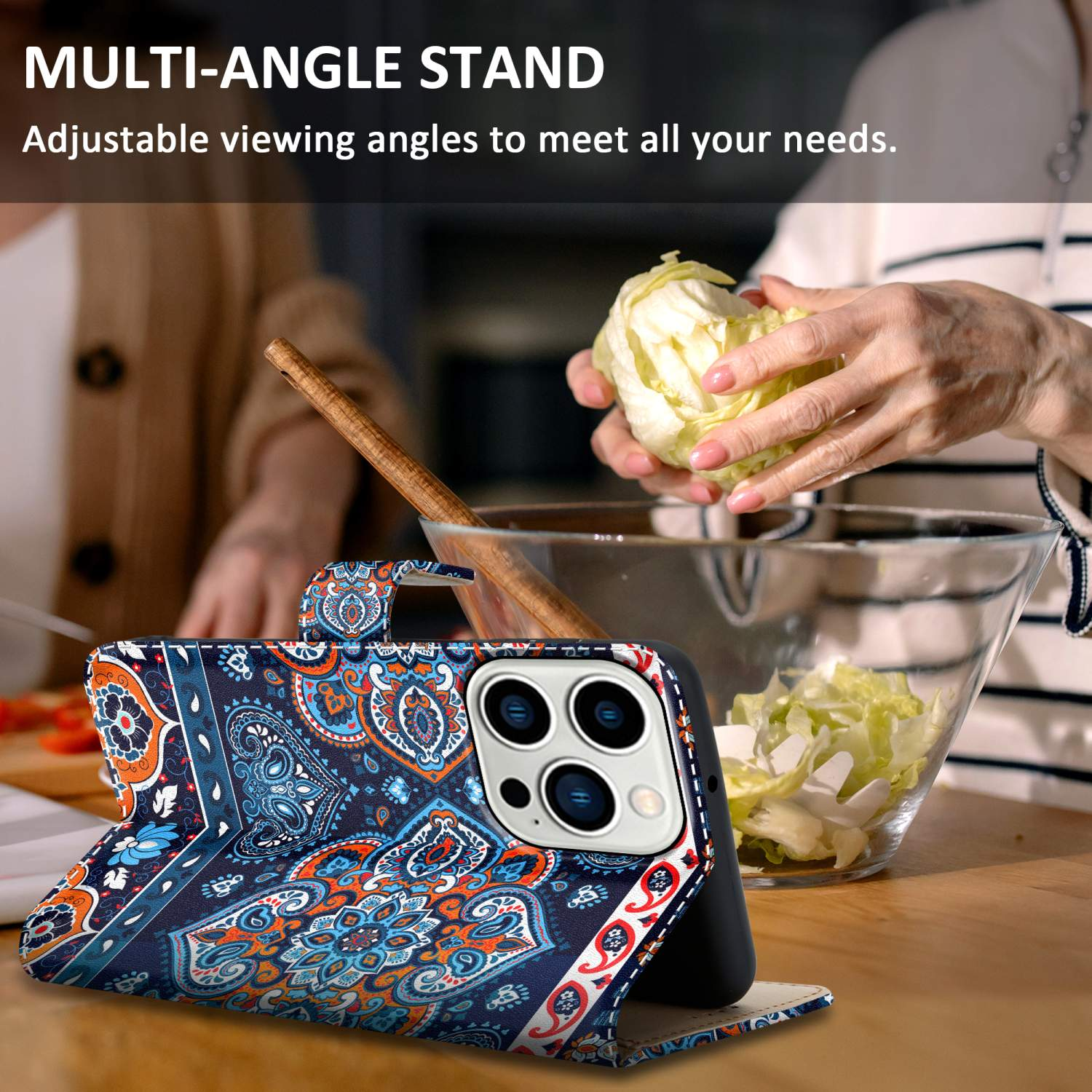 Eine Multi-Winkel-Handyhülle auf dem Tisch. Im Hintergrund bereitet eine Person Essen zu.