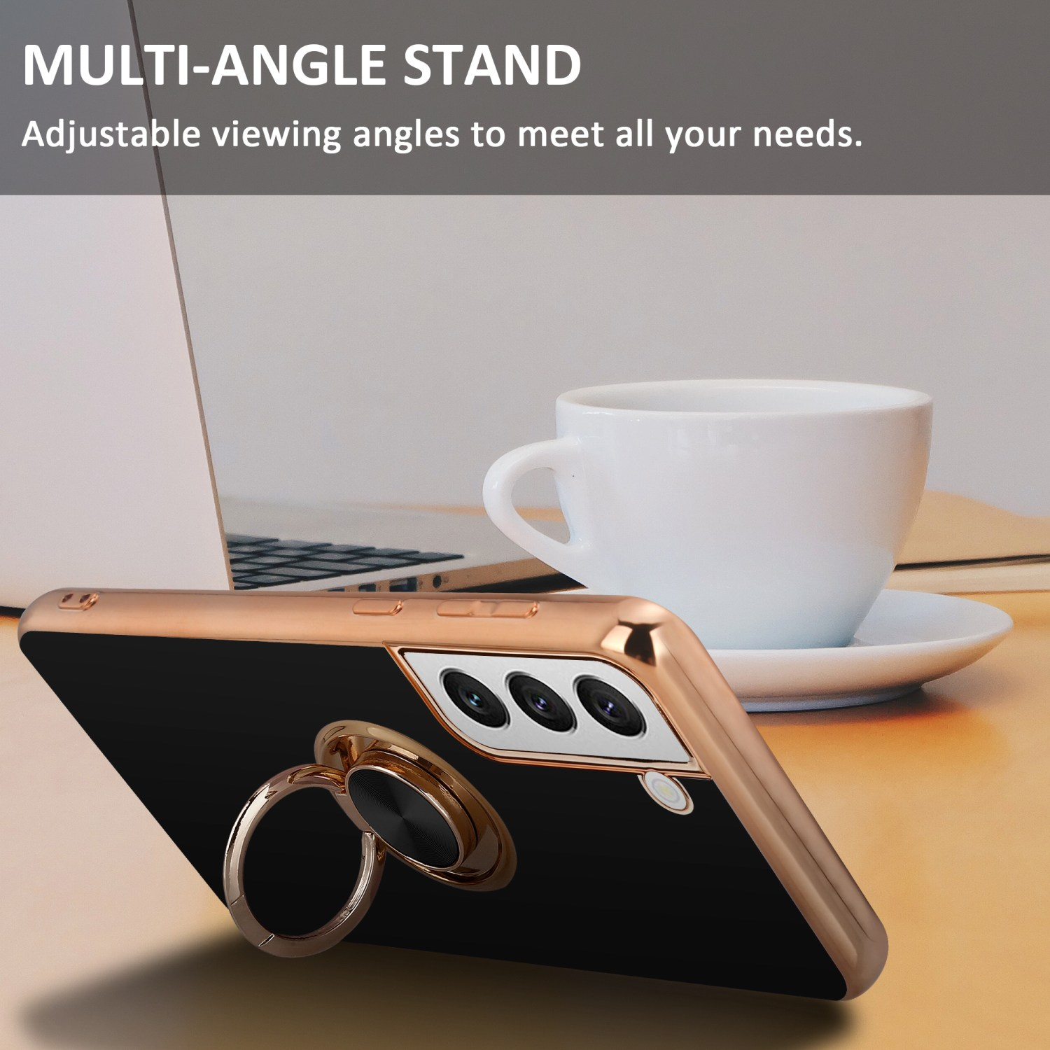 Custodia per telefono nera con anello di supporto dorato, su superficie in legno, con tazza bianca e laptop sullo sfondo.