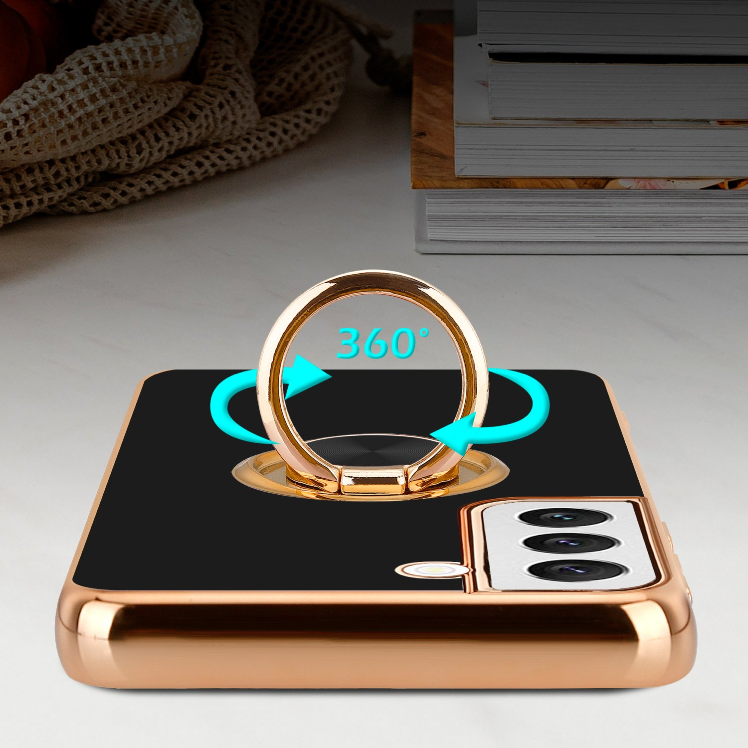 Una custodia per telefono dorata con retro nero e un supporto ad anello dorato. Frecce blu mostrano la rotazione.