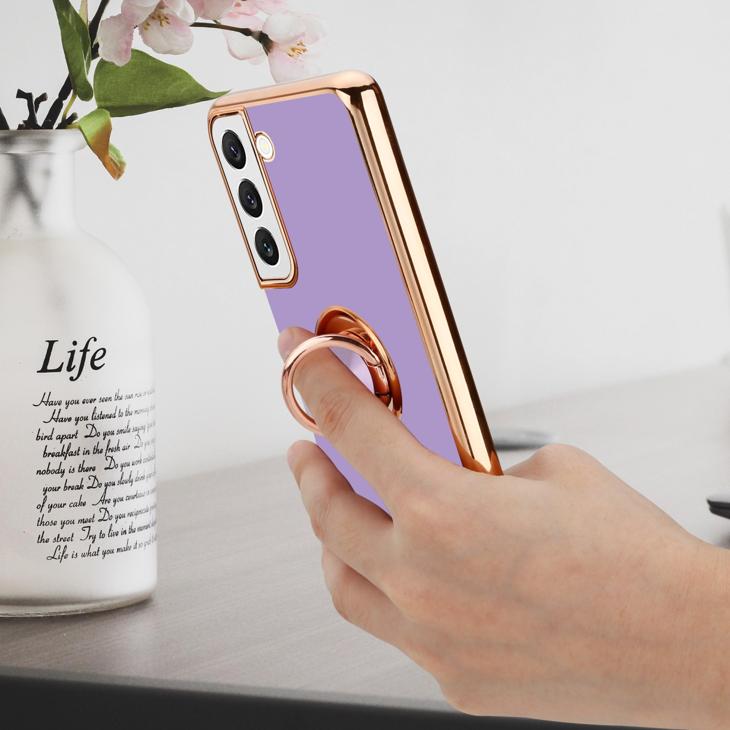 Custodia viola con anello d'oro. Il telefono è nella mano di qualcuno.