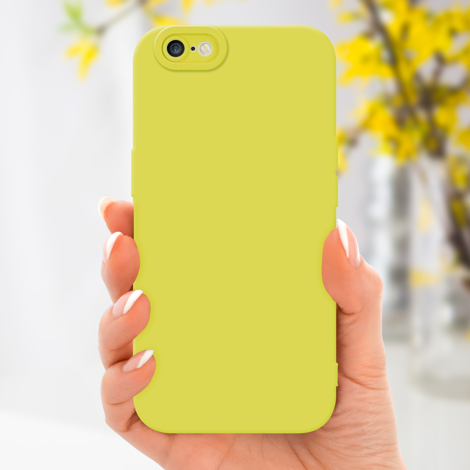Mano che tiene una custodia per telefono verde chiaro. Fiori gialli sullo sfondo.