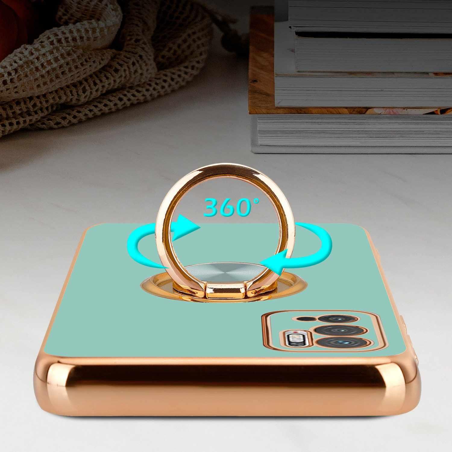 Custodia per telefono verde menta con un porta anello dorato e frecce attorno.