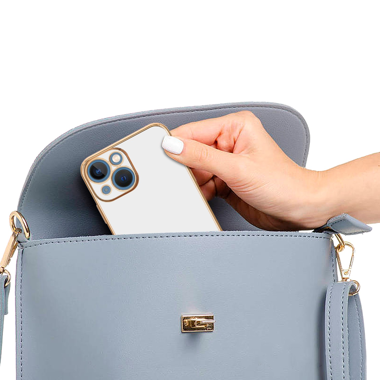 Frau legt Telefon in blaue Handtasche. Das Telefon ist in goldener Hülle. Weißer Hintergrund.