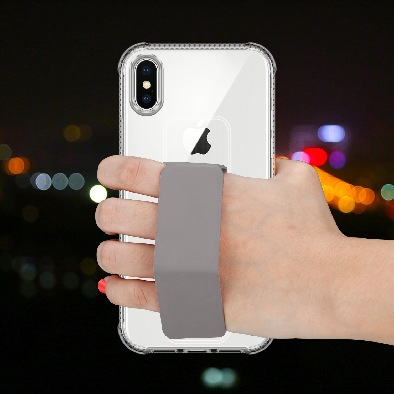 Eine Hand hält ein klares iPhone mit einem grauen Riemen. Der Hintergrund ist verschwommen und dunkel.