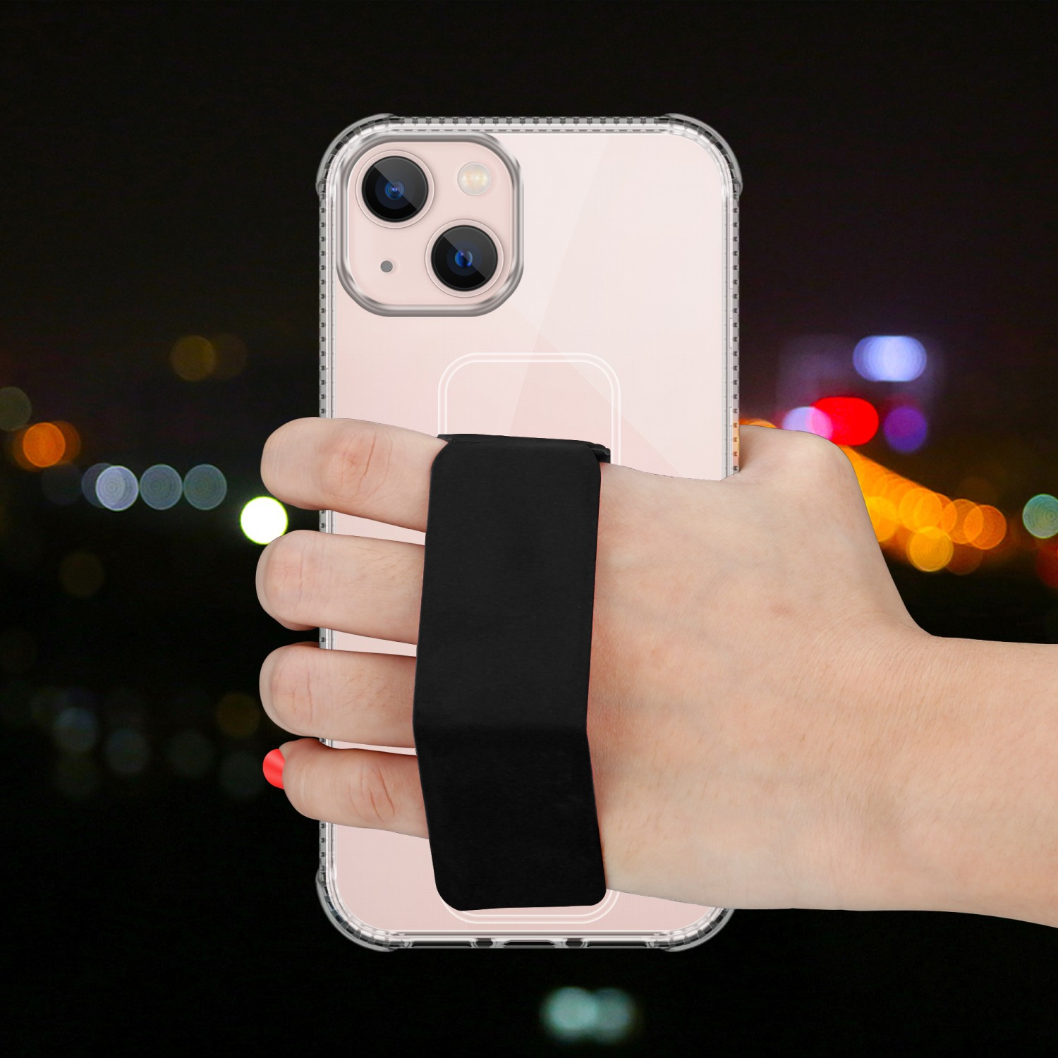 Hand hält Telefon mit schwarzem Griff, dunkler Hintergrund mit Lichtern.