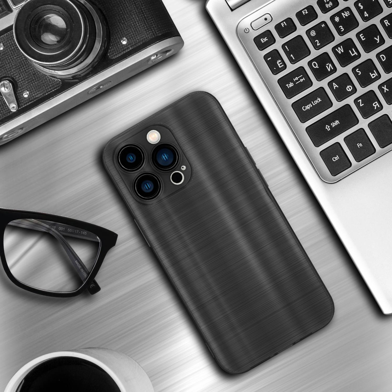 Eine schwarze Handyhülle auf einem Schreibtisch mit Laptop, Kamera, Brille und einer Kaffeetasse.