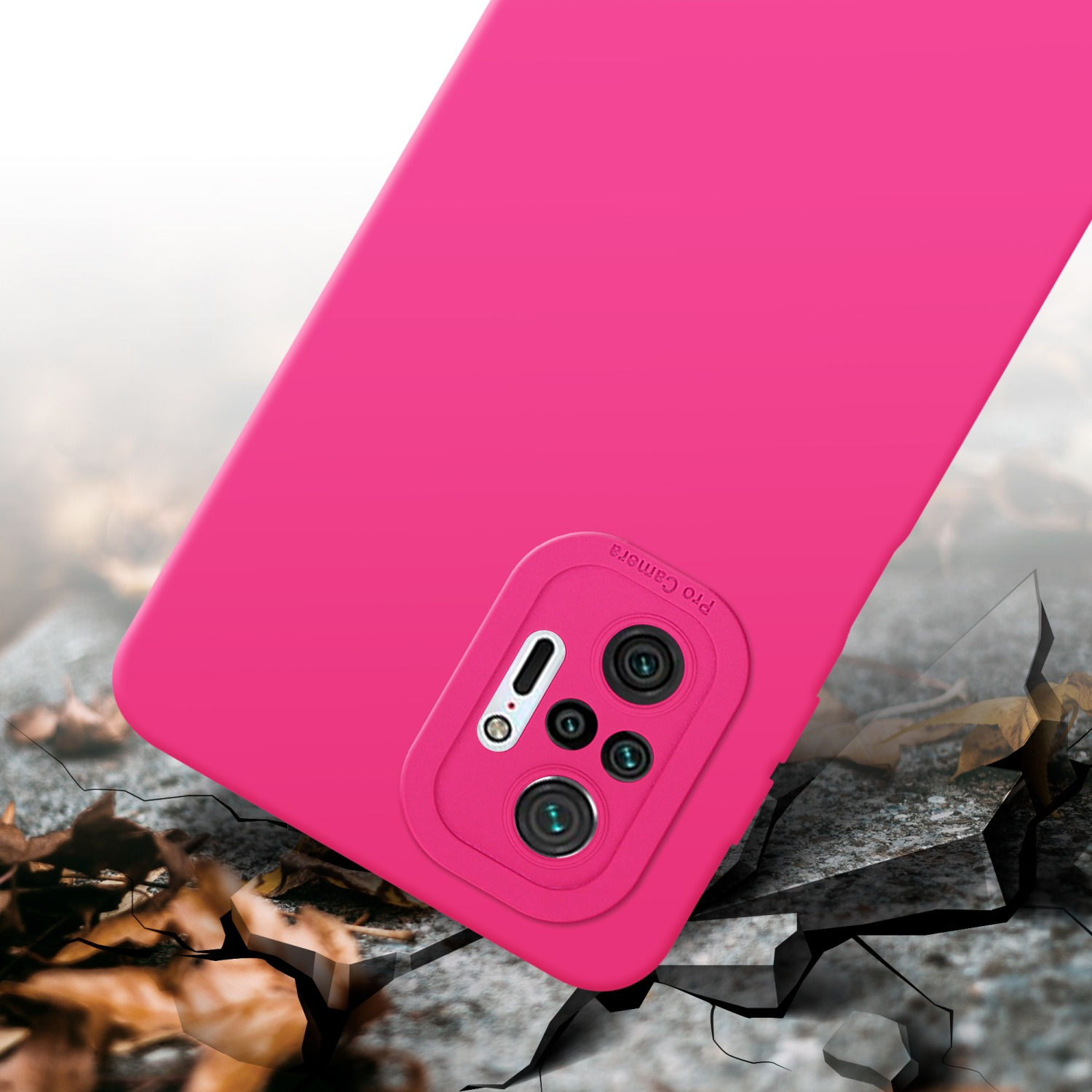 Una custodia per telefono rosa con protuberanza della fotocamera, posta su una superficie strutturata. Foglie cadute in primo piano.