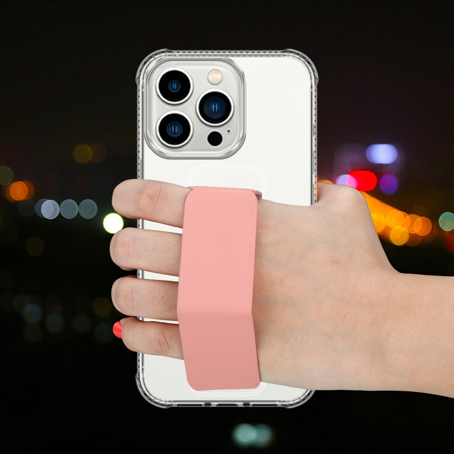 Telefon in klarer Hülle, gehalten von einer Hand mit rosa Riemen. Nacht-Hintergrund.