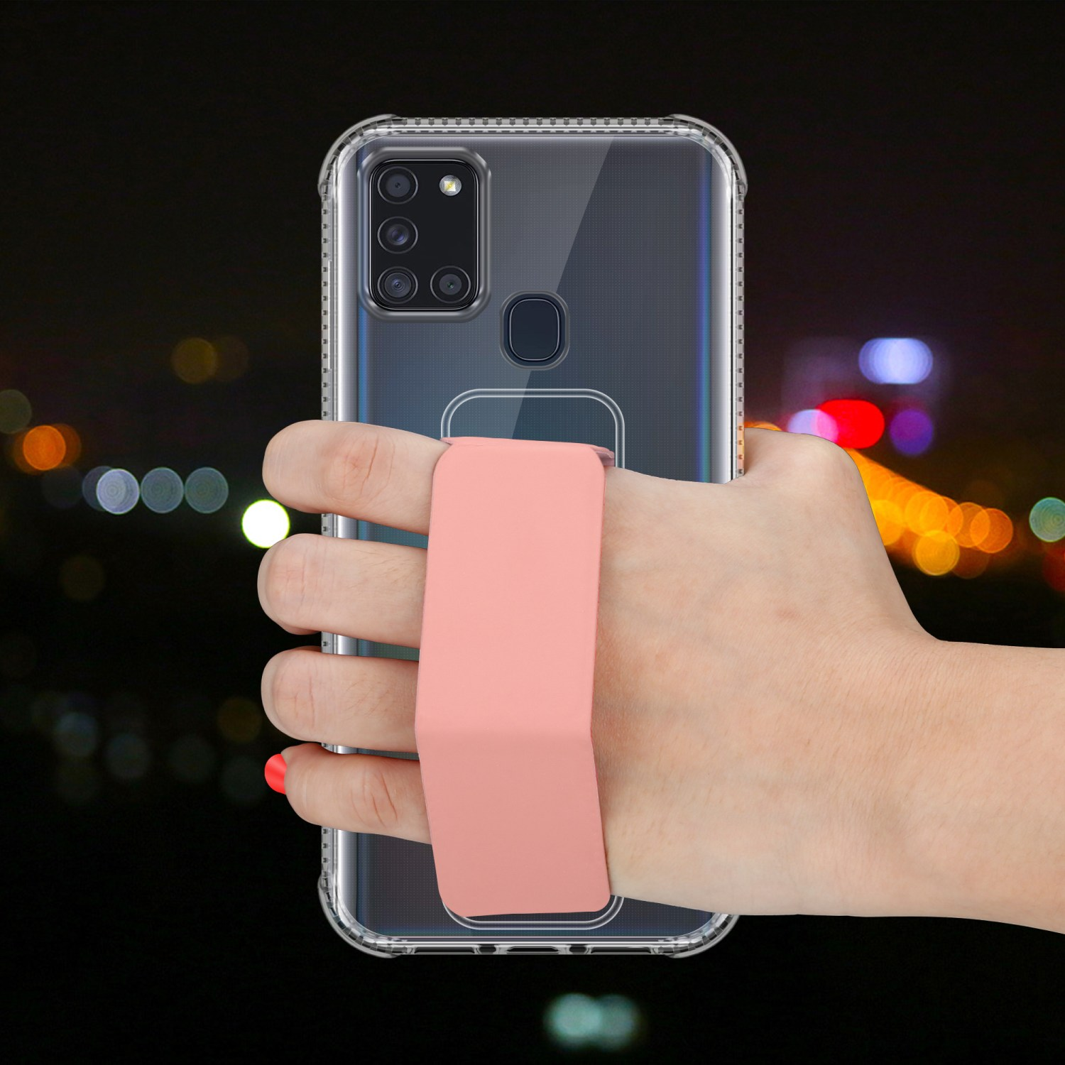 Eine Hand hält ein Telefon mit einem rosa Riemen. Der Hintergrund ist dunkel und verschwommen.