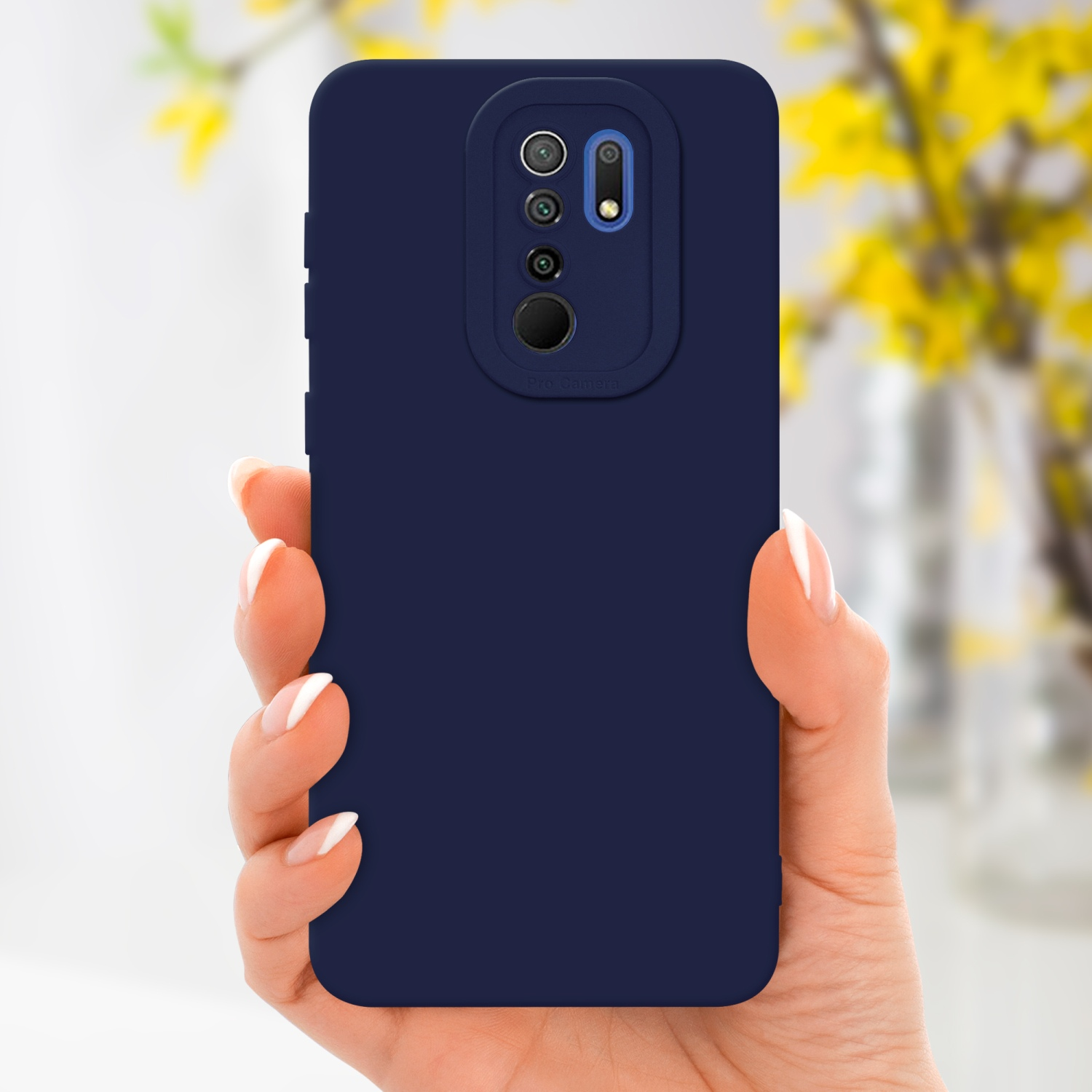 Una mano che tiene una custodia blu scuro con modulo fotocamera visibile, fiori gialli sullo sfondo.