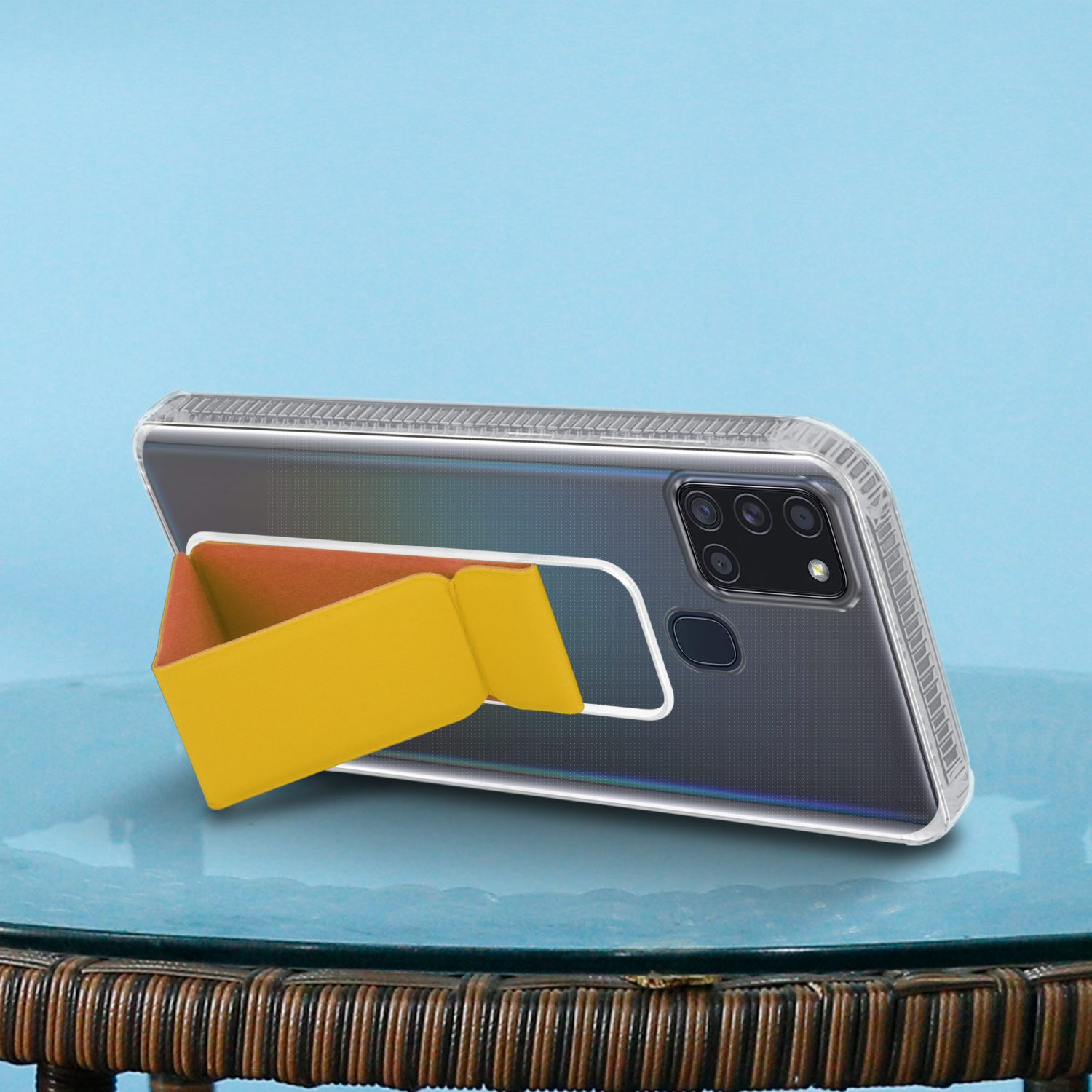 Telefon mit gelbem Ständer. Das Telefon liegt auf einem Tisch. Der Hintergrund ist hellblau.