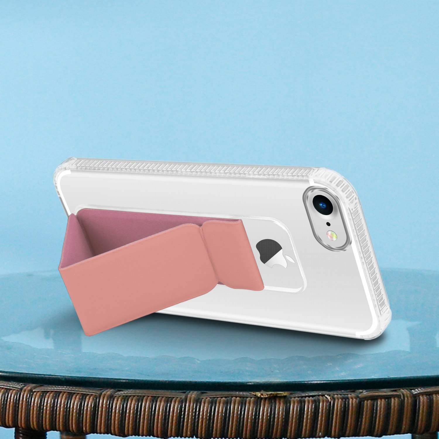 Telefon mit rosa Ständerhülle. Es liegt auf einem Tisch mit blauem Hintergrund.
