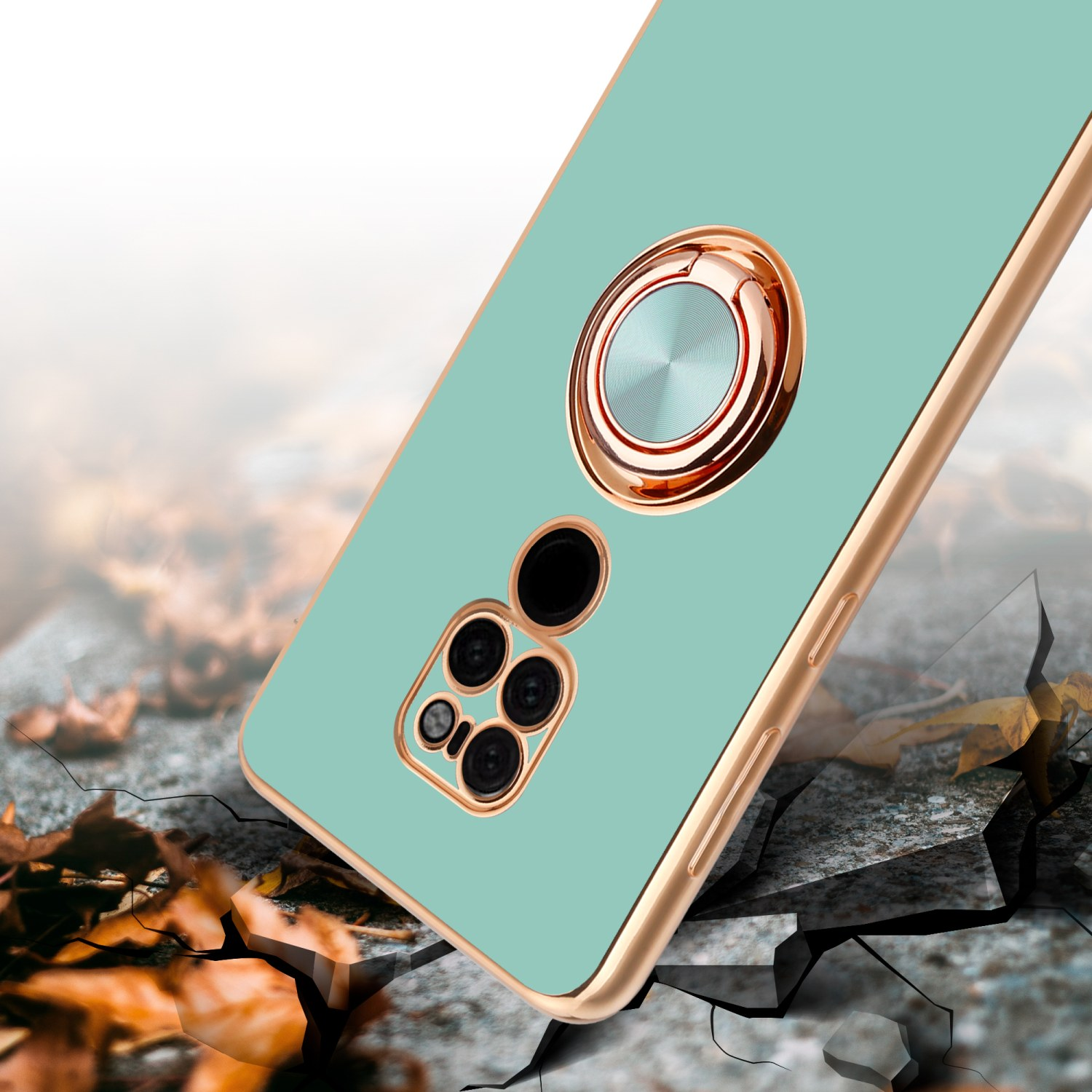Custodia per telefono color menta con anello dorato, terreno crepato e foglie che cadono.