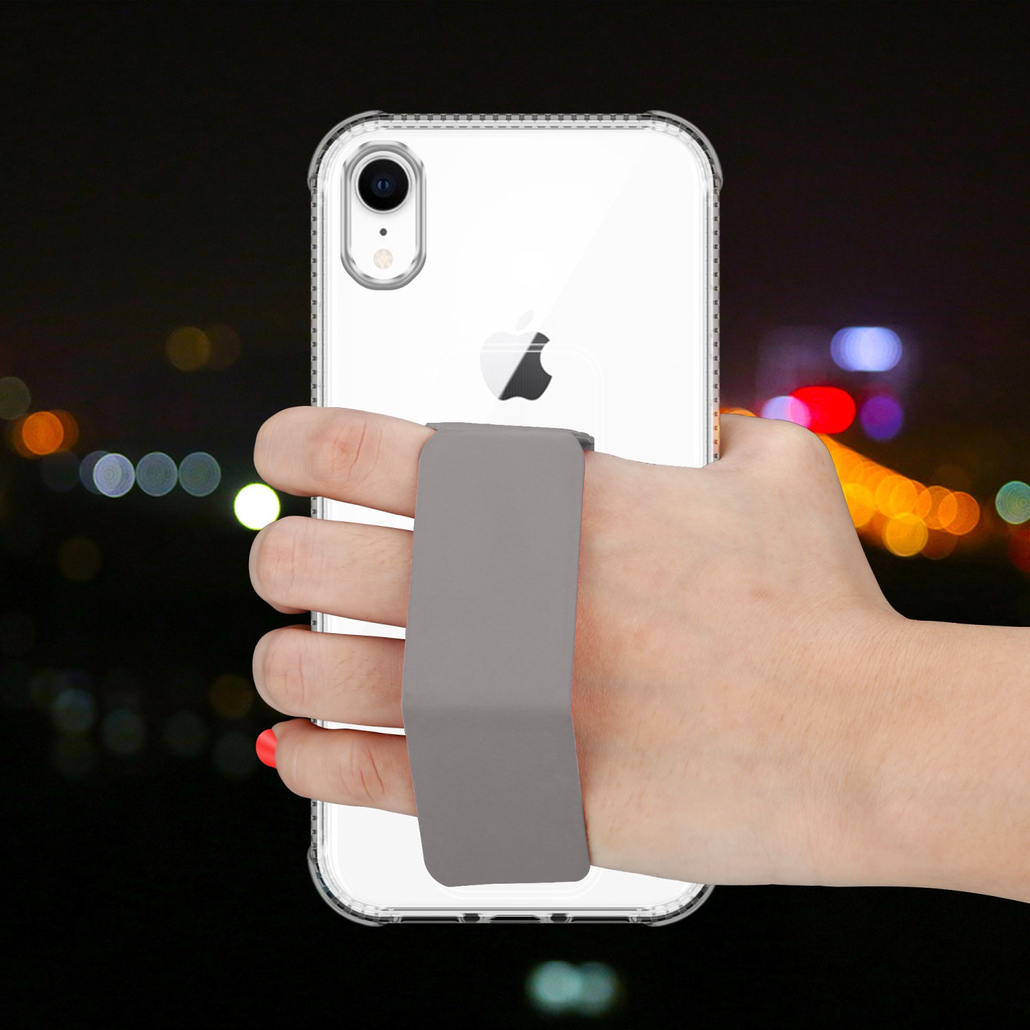 Hand, die ein Telefon in einer durchsichtigen Hülle mit einem grauen Riemen vor einer verschwommenen Nachtszene hält.