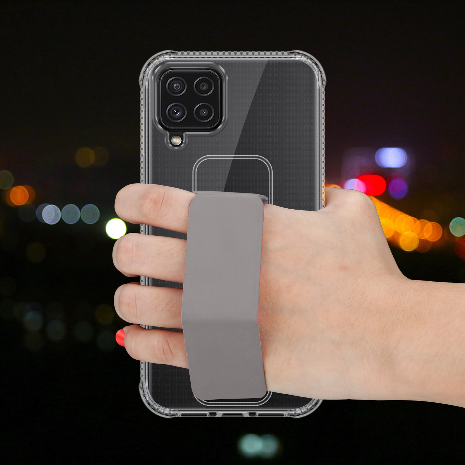 Eine Hand hält eine transparente Handyhülle mit grauem Riemen, mit verschwommenem Hintergrund von Stadtlichtern.