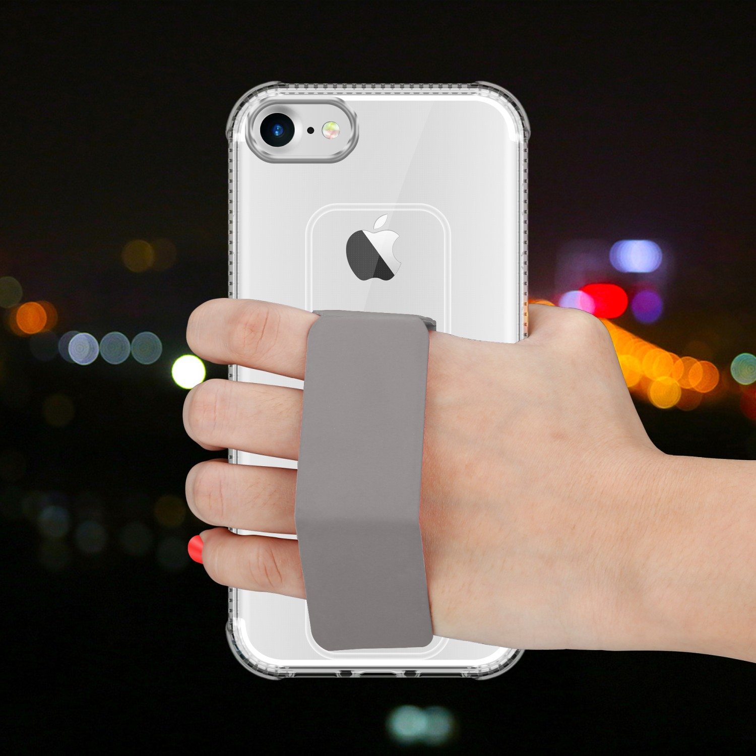 Hand, die ein klares Telefon mit grauem Riemen hält. Dunkler Hintergrund mit verschwommenen Lichtern.