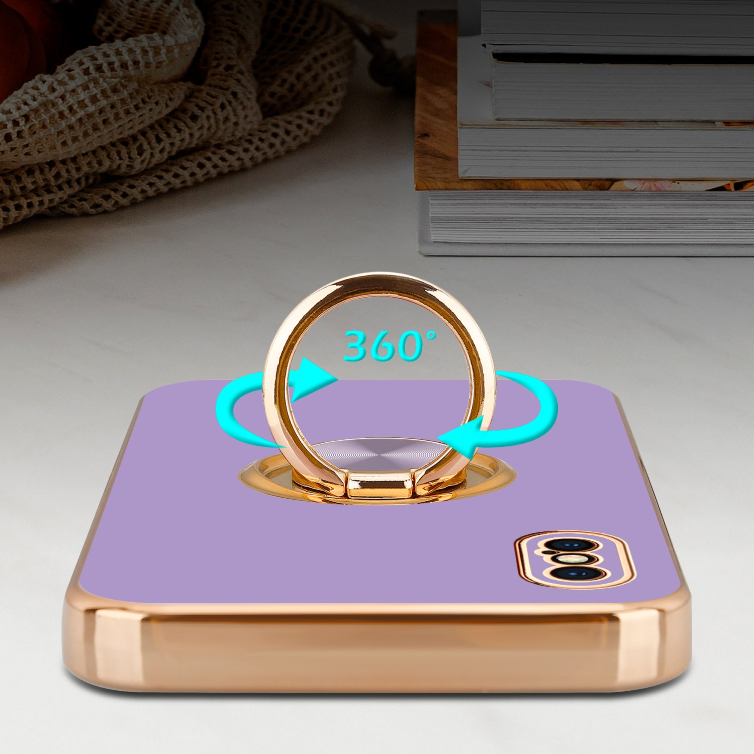Lila Handyhülle mit goldenem Ringhalter, auf einem Tisch mit 360-Grad-Drehanzeige.
