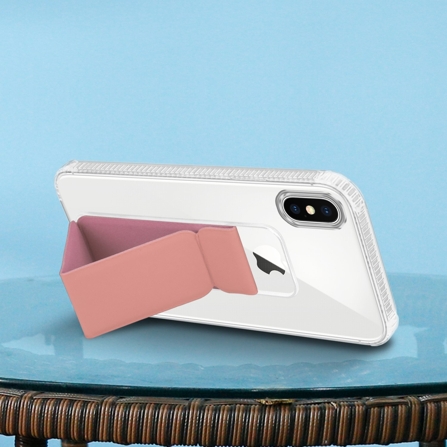 Telefon in transparenter Hülle mit rosa Ständer, auf blauer Oberfläche. Blauer Hintergrund.