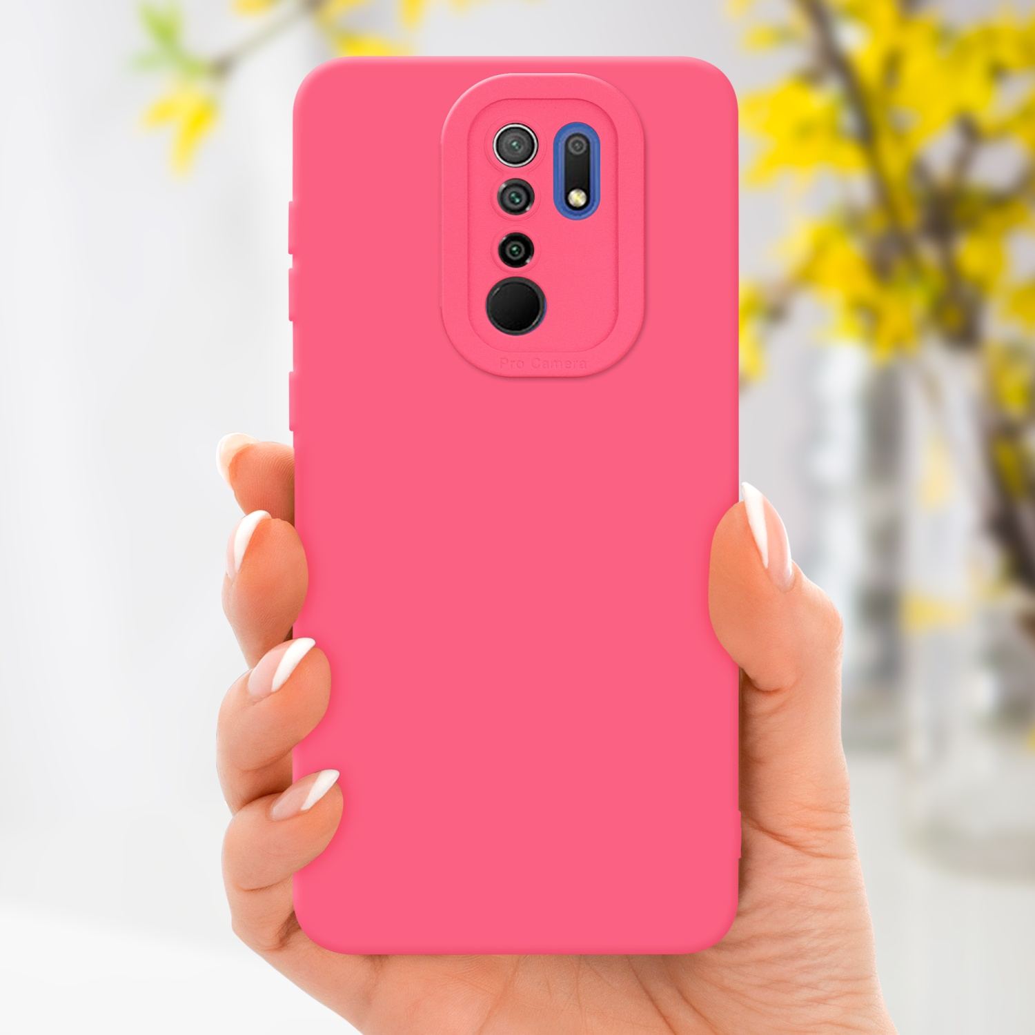 Una mano tiene in mano una custodia rosa per telefono. Fiori gialli sullo sfondo sfocato.