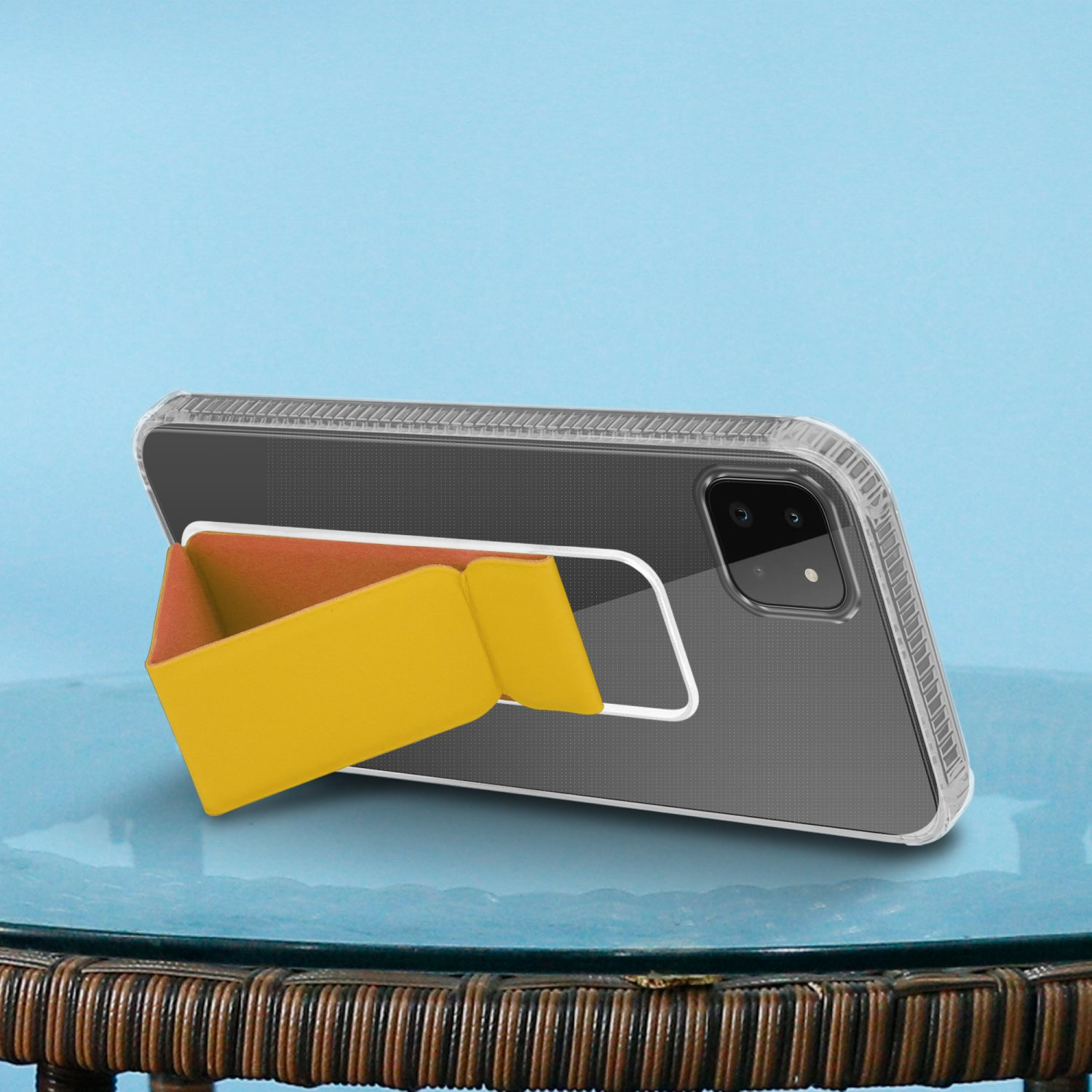 Ein Telefon mit gelbem Halter liegt auf einem Tisch. Der Hintergrund ist blau.