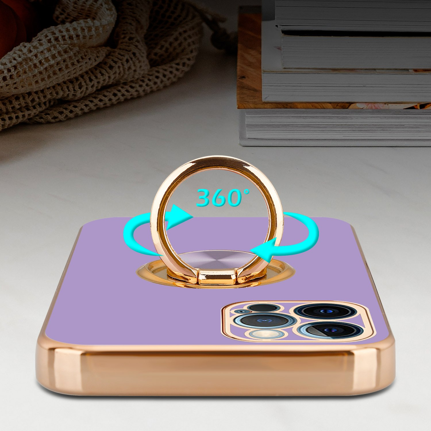 Eine lila Handyhülle mit einem goldenen Ringhalter, der eine 360-Grad-Drehung zeigt. Das Telefon liegt auf einer weißen Oberfläche.