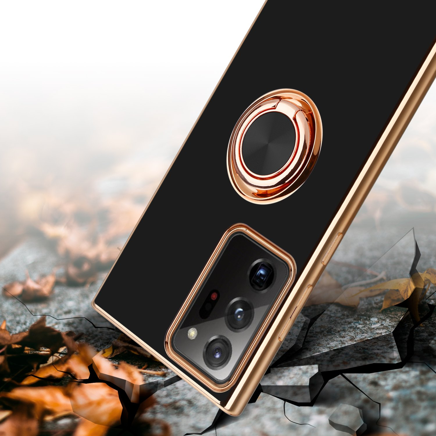 Eine schwarze Handyhülle mit Goldring und beschädigtem Hintergrund mit Rissen und Herbstlaub.